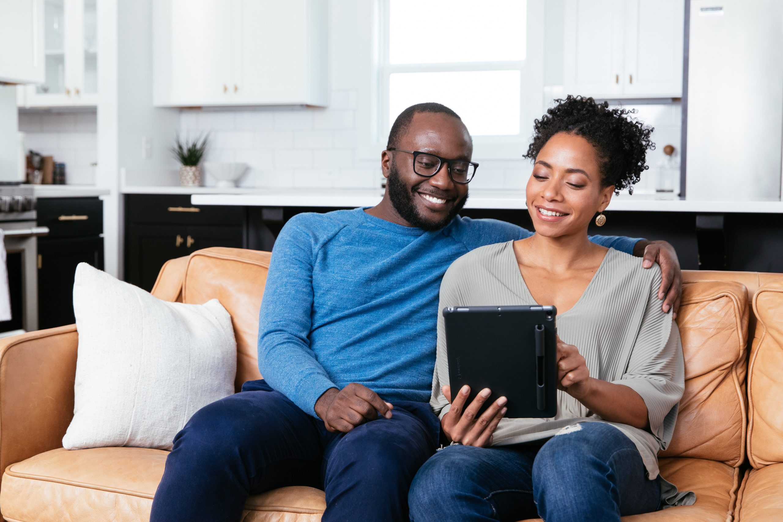 Couple on a couch looking at tablet