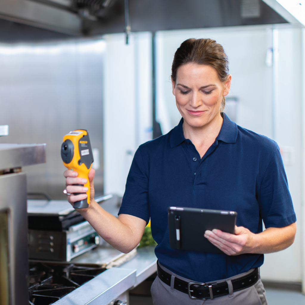 Woman looking at tablet in industrial kitchen